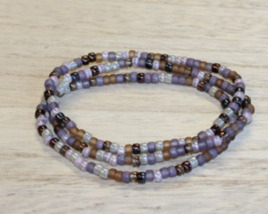 This pretty handmade stretch bracelet is in the colors of violet and neutral colors.